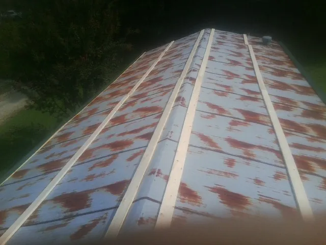 Rusted metal roof panels with new wood purlins before replacement — Storm Damage Roof Repair in Remsen by Roofing Brothers