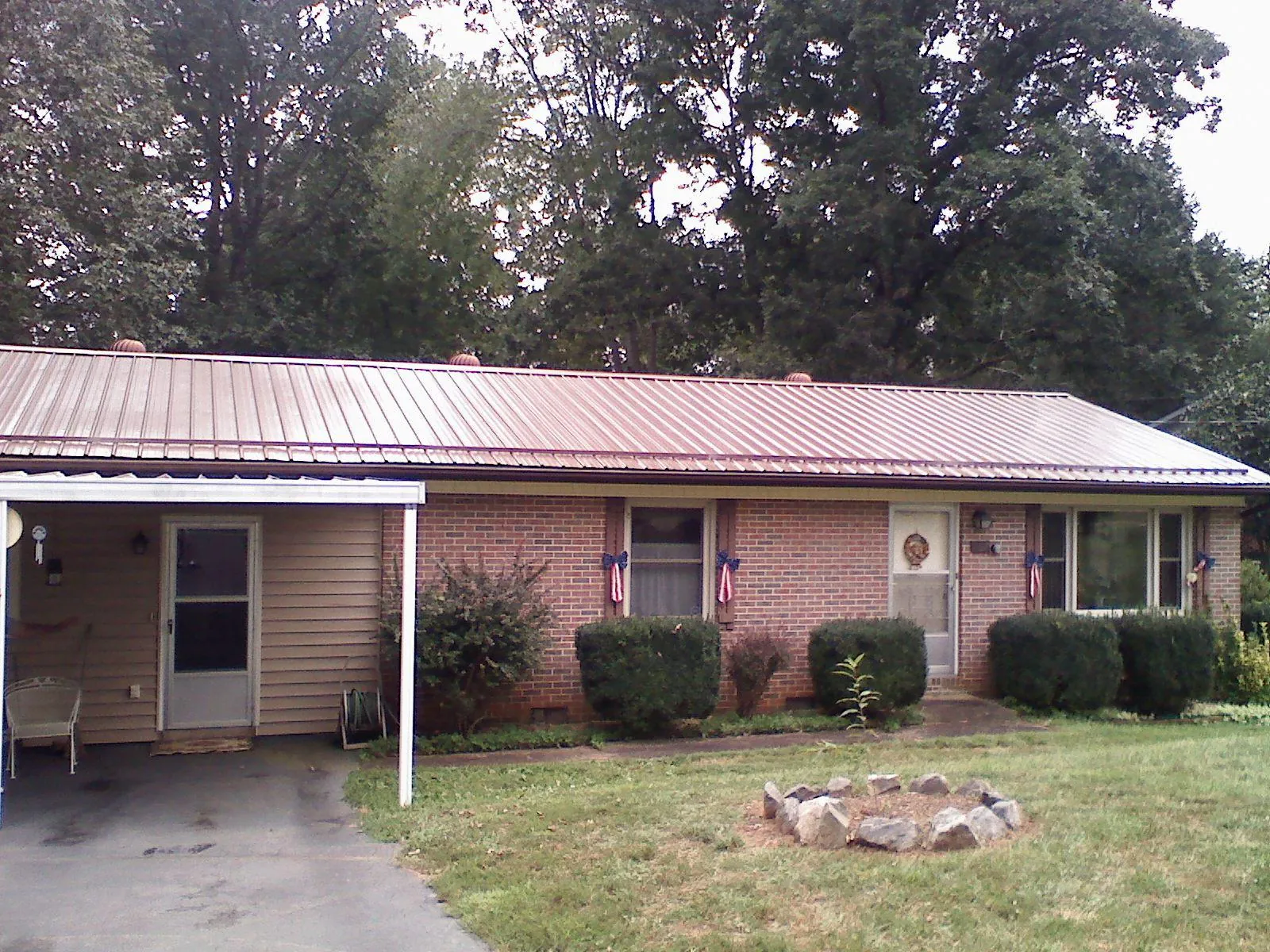 Bronze metal roof and carport on a brick ranch home — Roof Repair work by our crew in Remsen